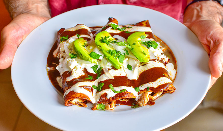 Enchiladas being served on a plate