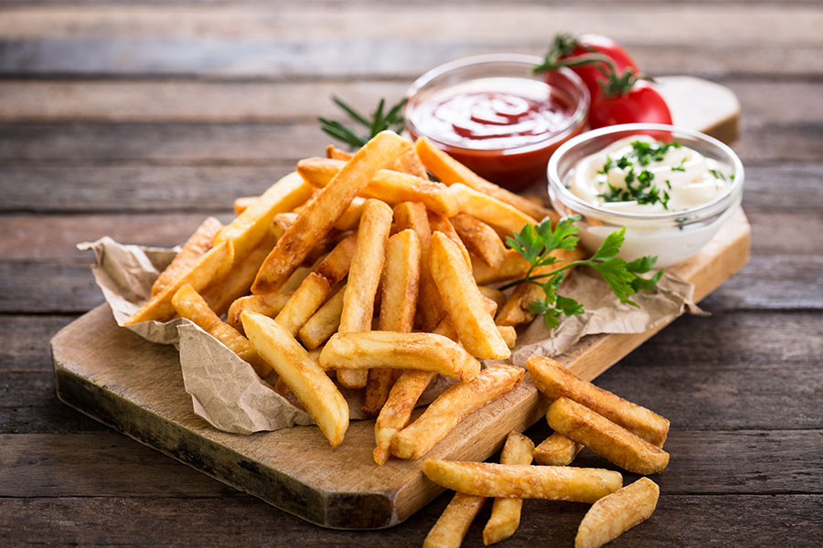 French fries on a serving tray with ketchup and ranch dips
