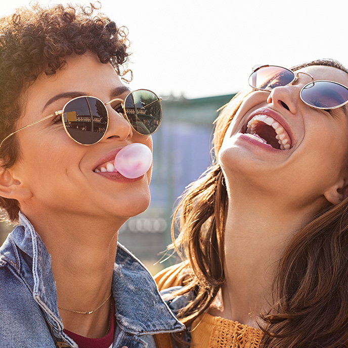 Two friends wearing sunglasses and laughing
