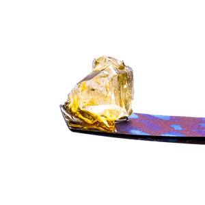 Live Resin Cannabis Diamonds on Titanium Dab Tool with a White Background